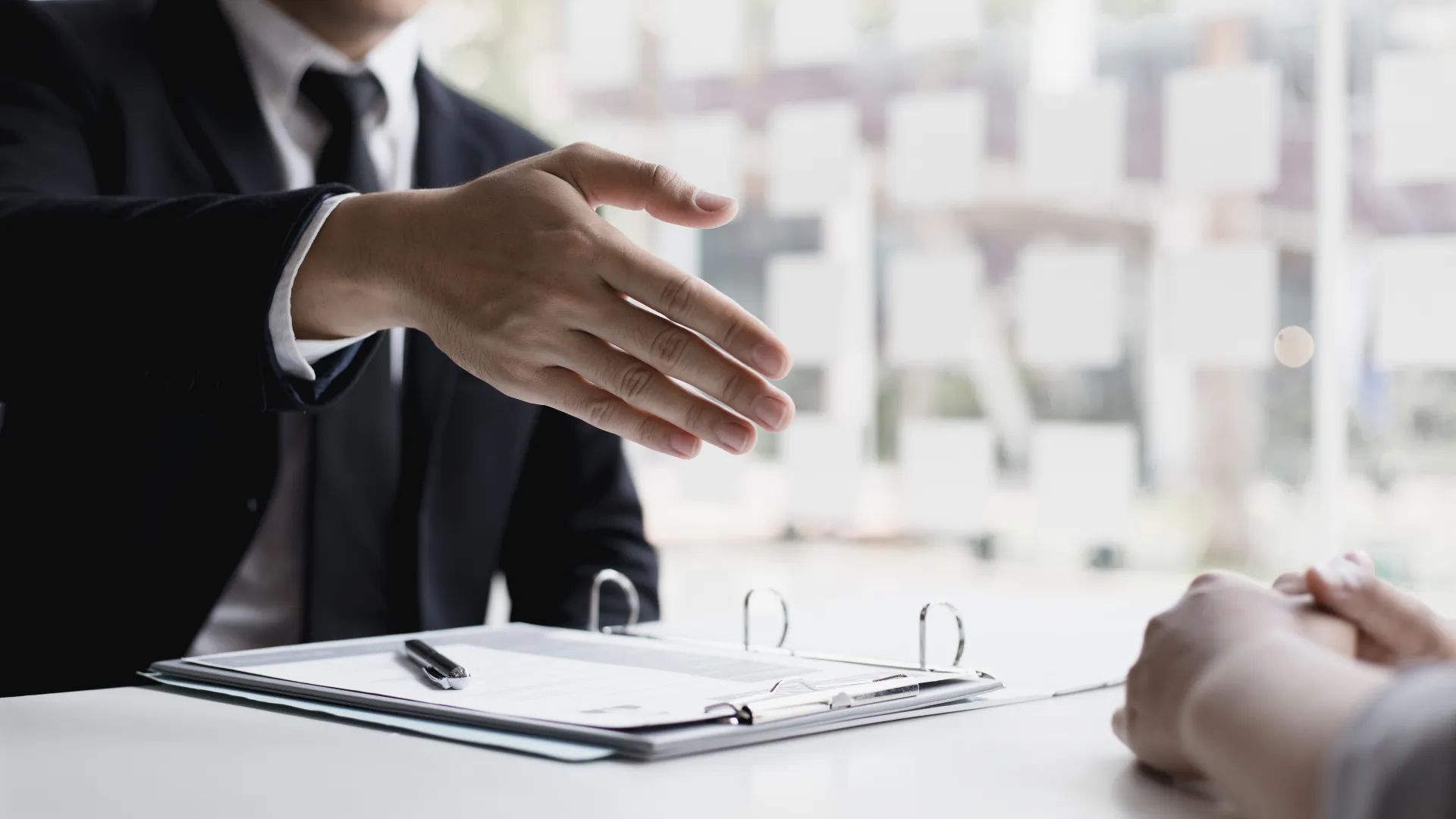 Interviewer offering a handshake to a job candidate, careers at Shiv Om E-Tec