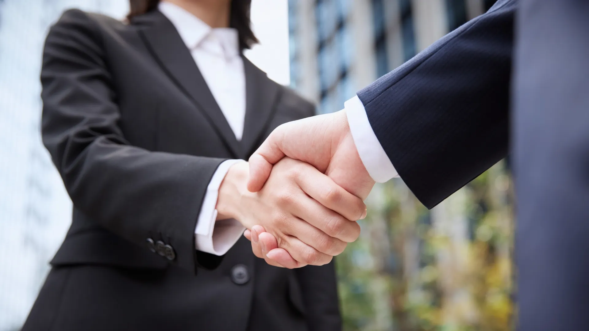 Business handshake between an OEM buyer and a precision parts supplier